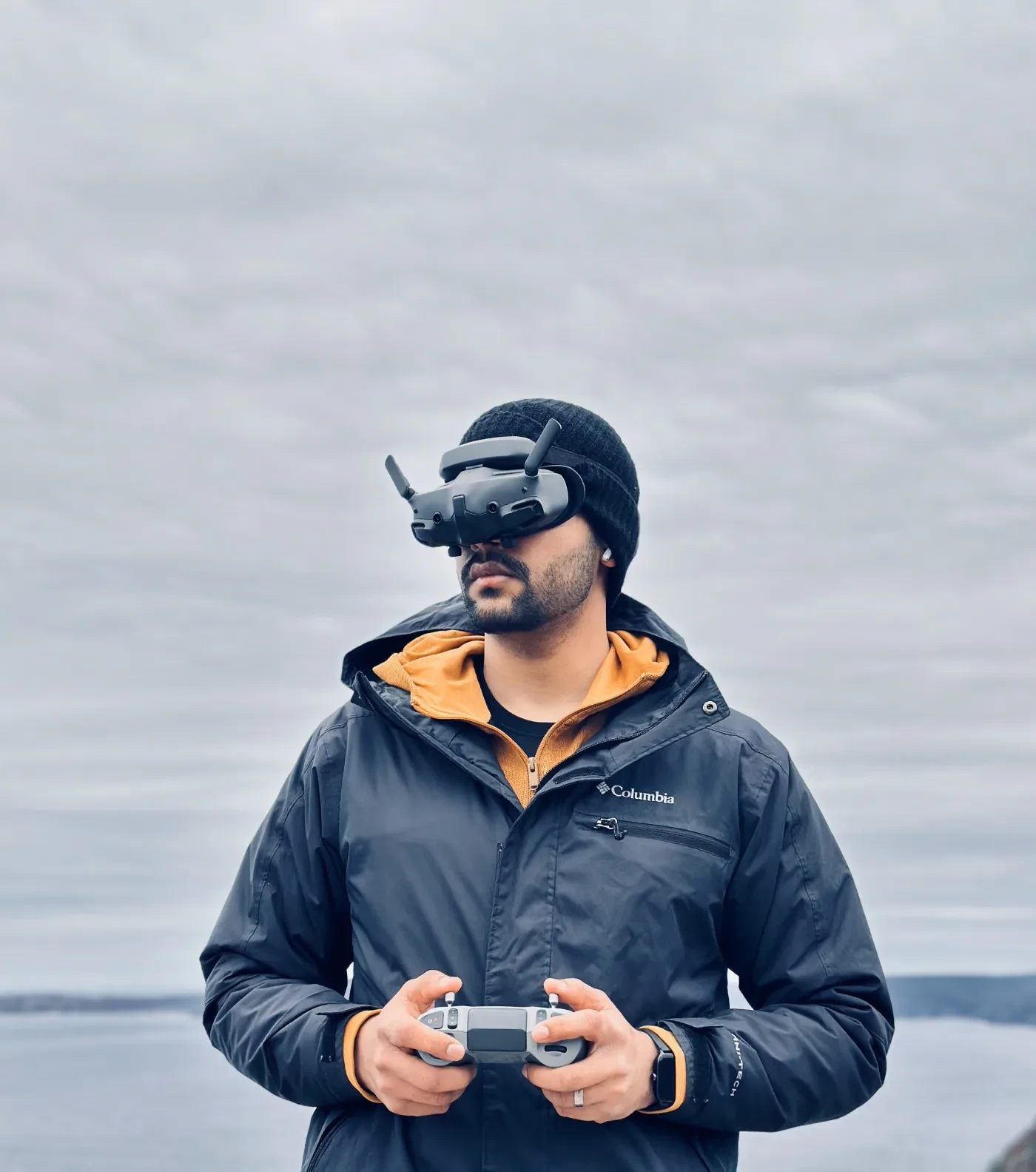 Adeel wearing FPV goggles and holding his drone controller on the Newfoundland coast