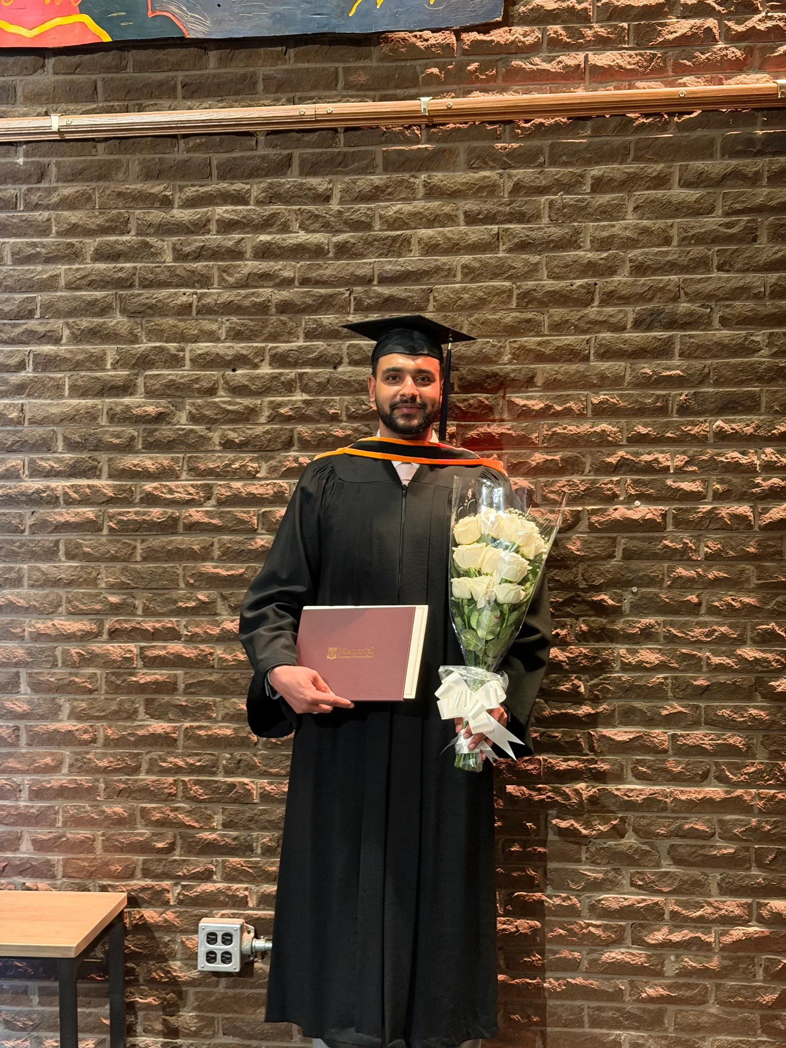 Adeel at graduation with his diploma